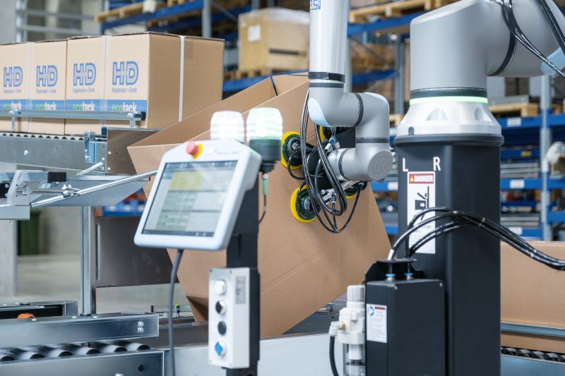 Ein kollaborativer Roboter richtet Kartons auf Ein kollaborativer Roboter richtet Kartons auf